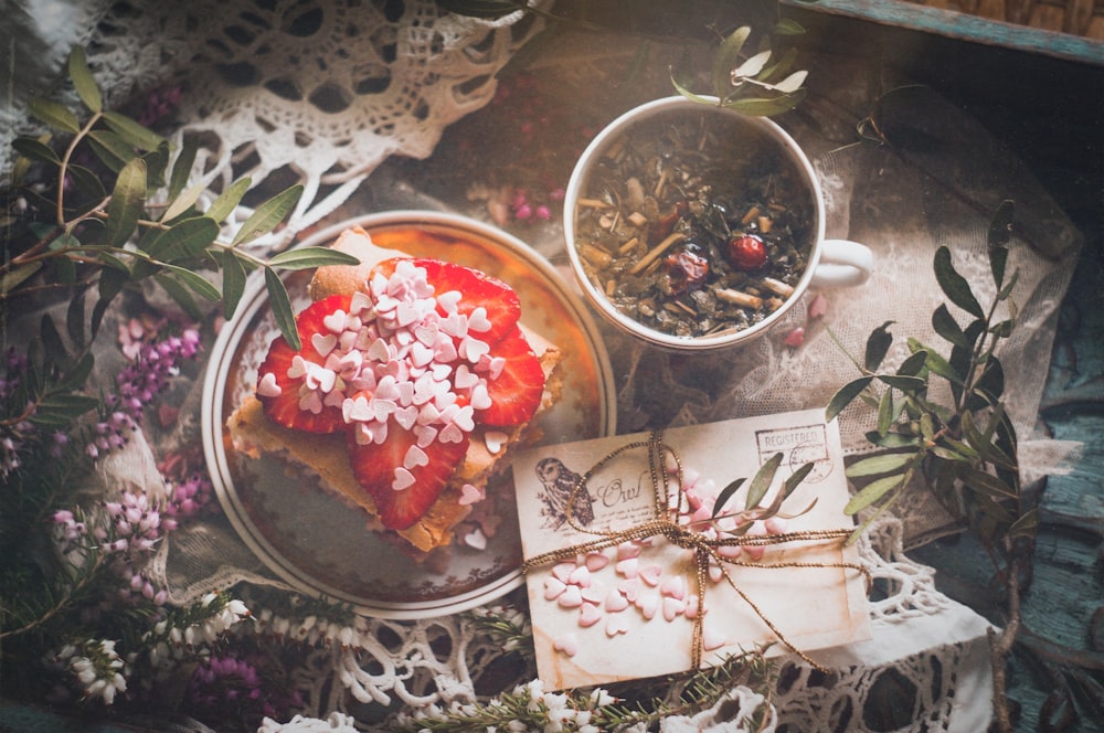 a table topped with a plate of food and a cup of tea