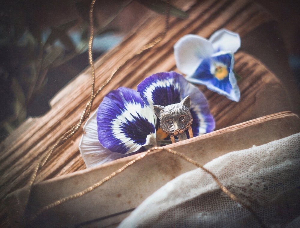 a blue and white flower sitting on top of a wooden table