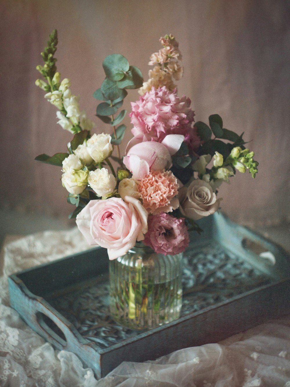 a glass vase filled with flowers on top of a table