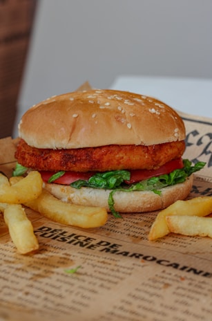 A crispy chicken burger served with a side of fries.