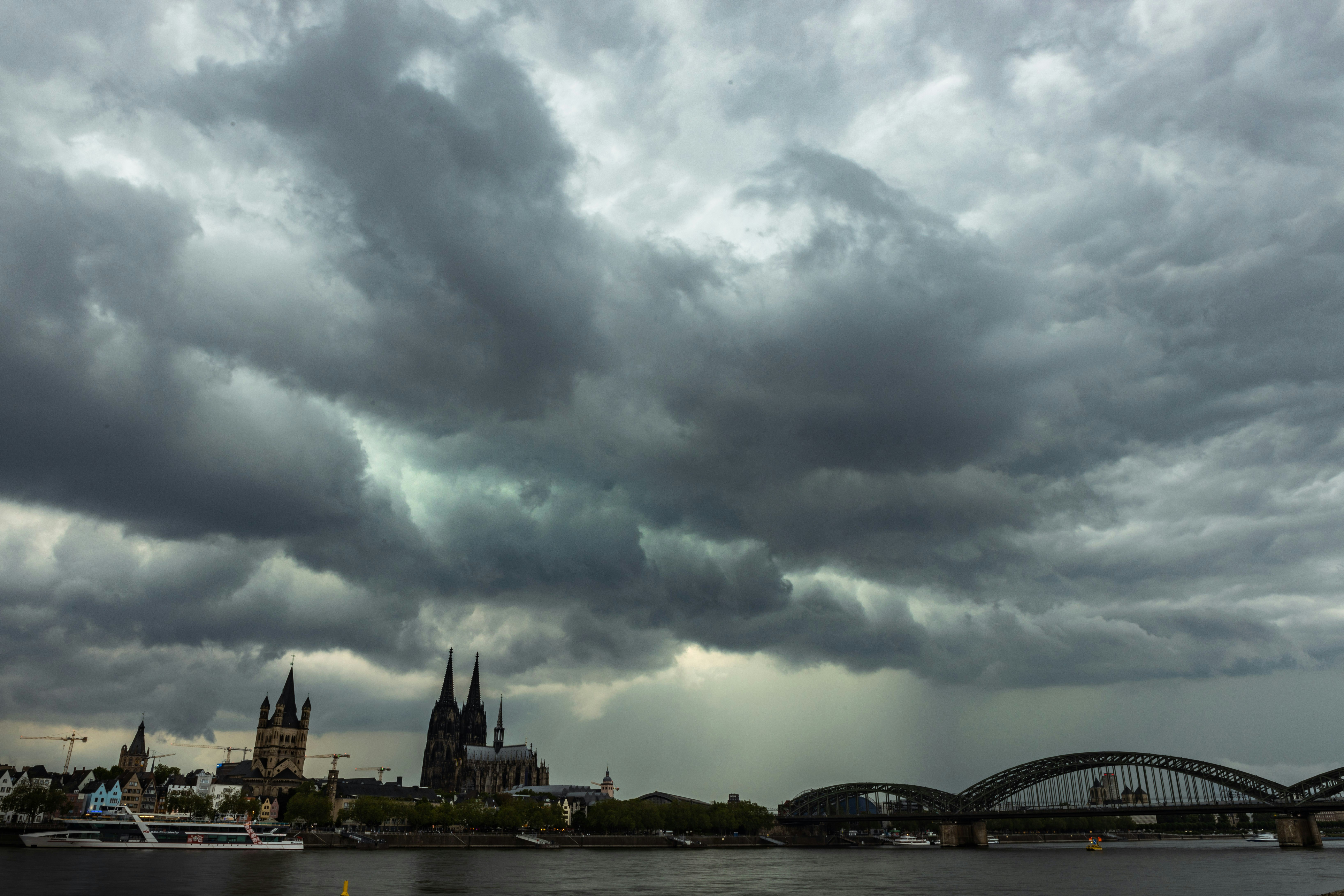 A cloudy sky over a river with a bridge in the foreground photo – Free ...
