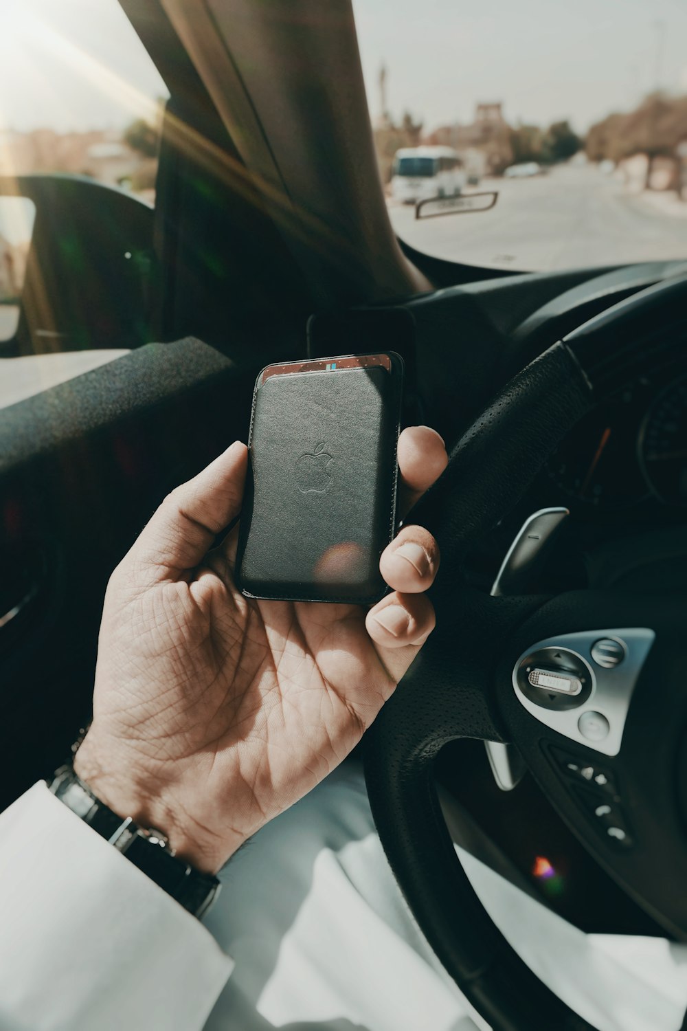 a person holding a cell phone while driving a car