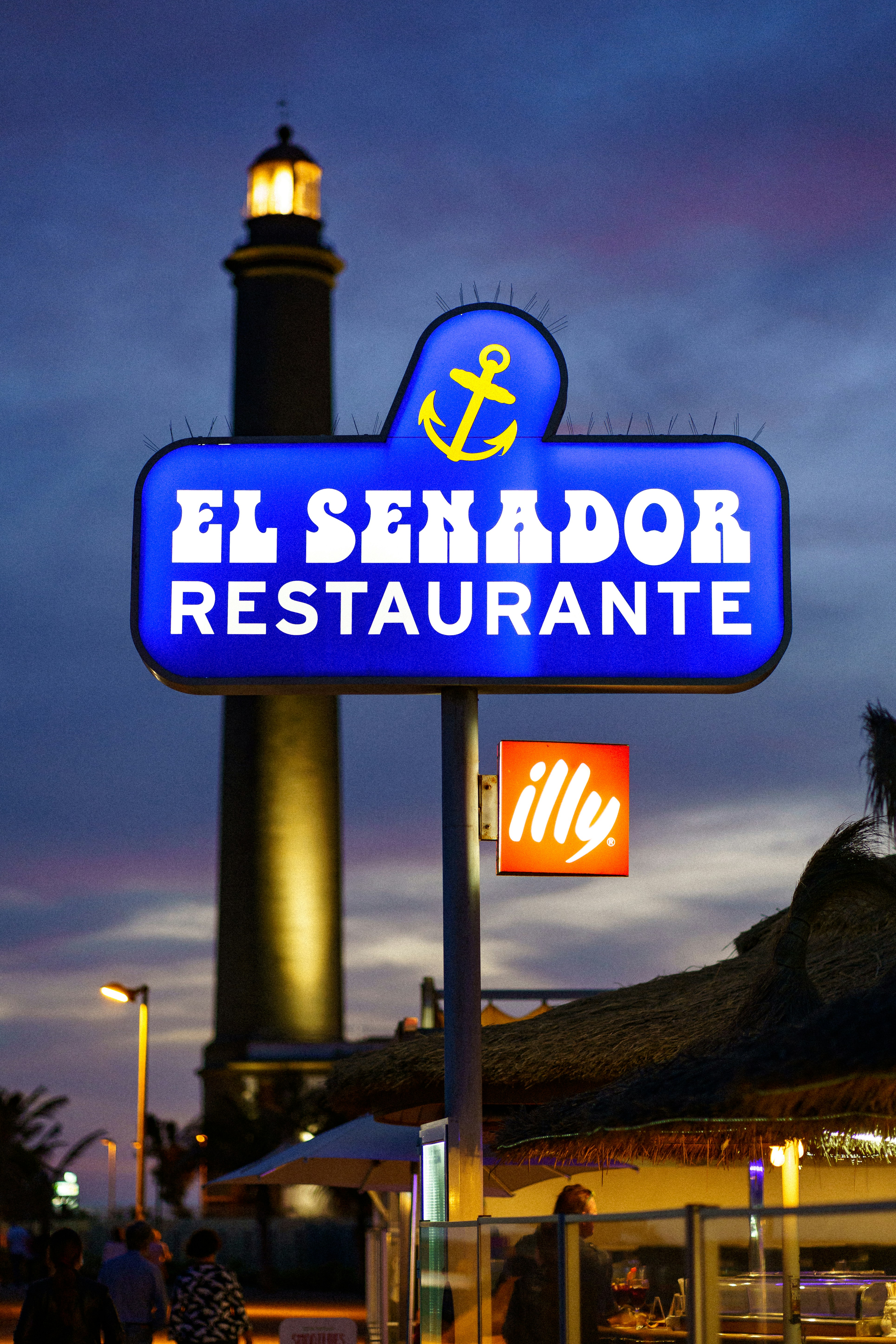 A restaurant sign with a lighthouse in the background photo – Free Blue ...