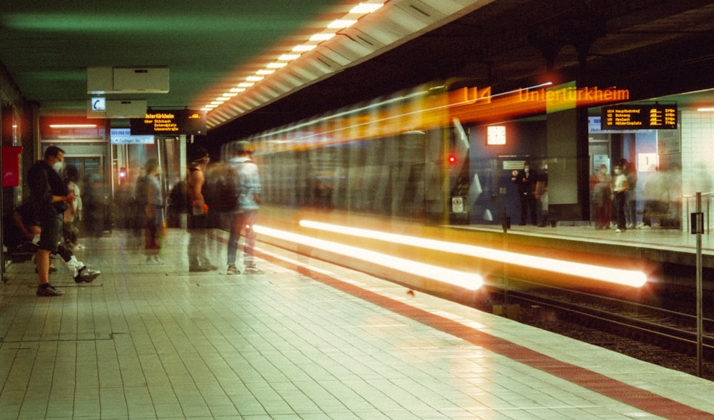 a group of people waiting for a train at a train station