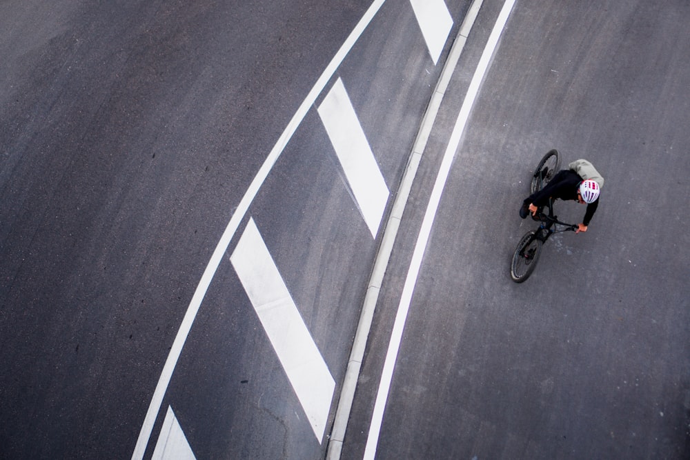 Un hombre montando en bicicleta por una carretera con curvas