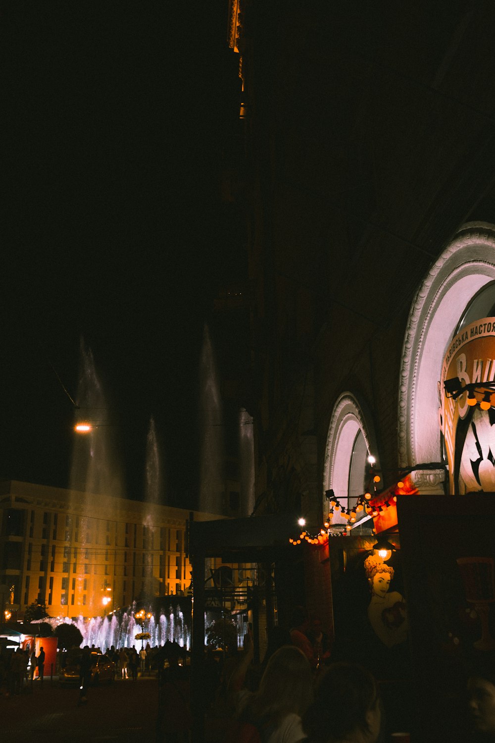 a building with a fountain in front of it at night