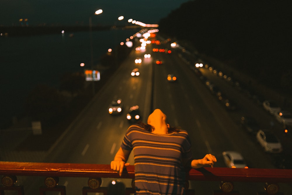 a person standing on a balcony looking at a highway