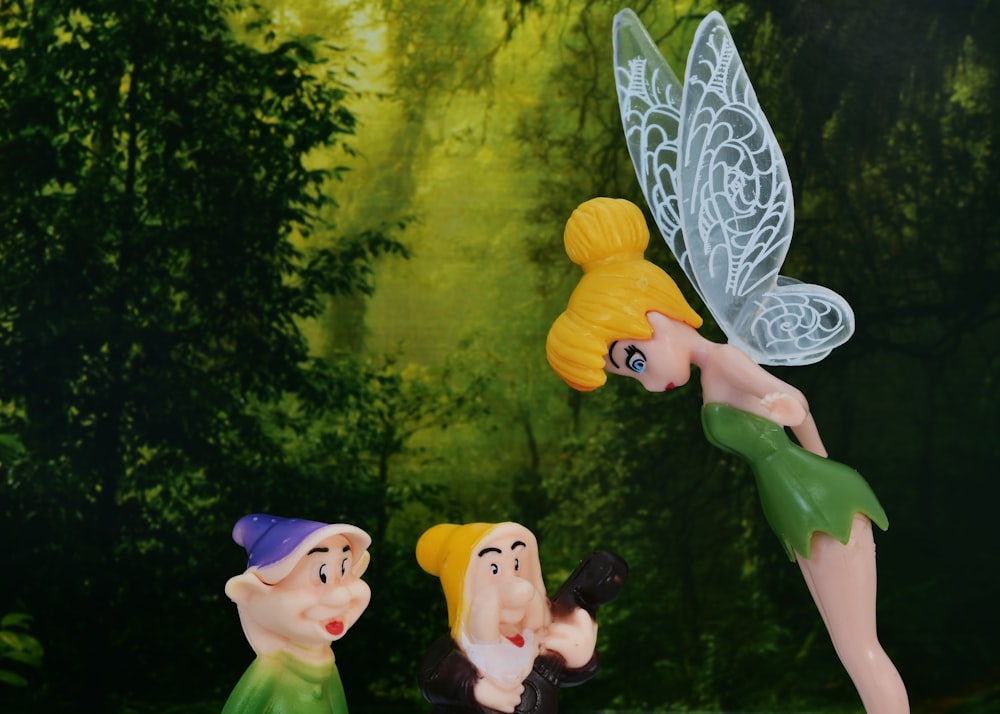 a group of toy figurines of tinkerbell and snow white