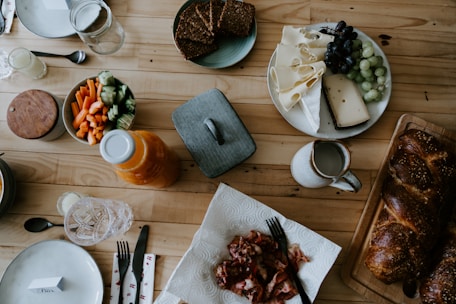 a wooden table topped with plates of food