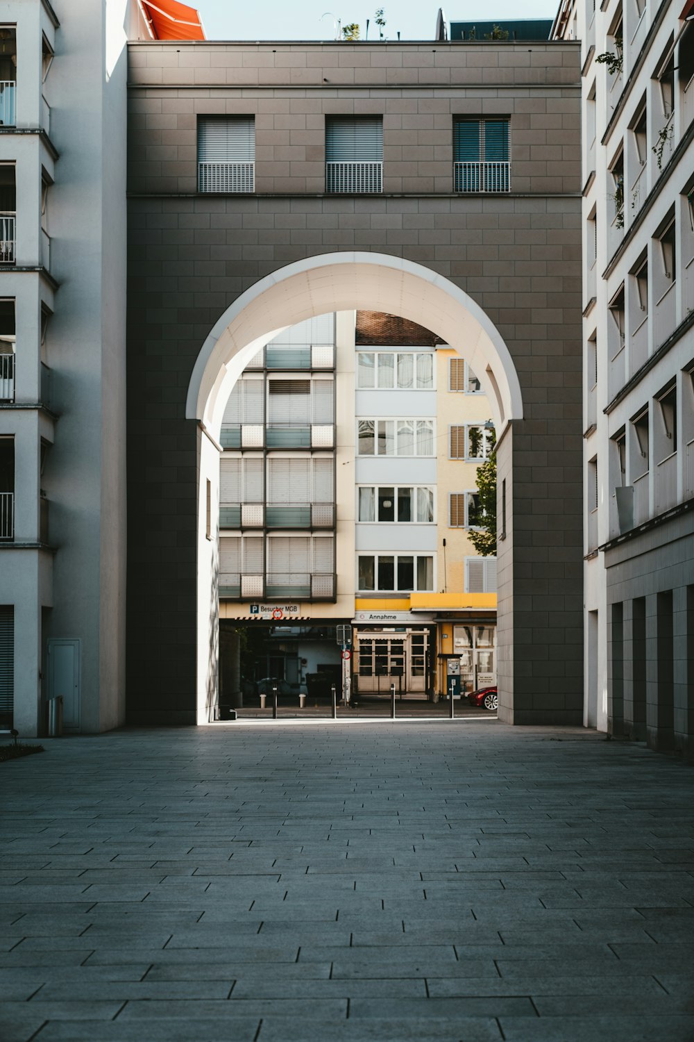 an arch in the middle of a courtyard between two buildings
