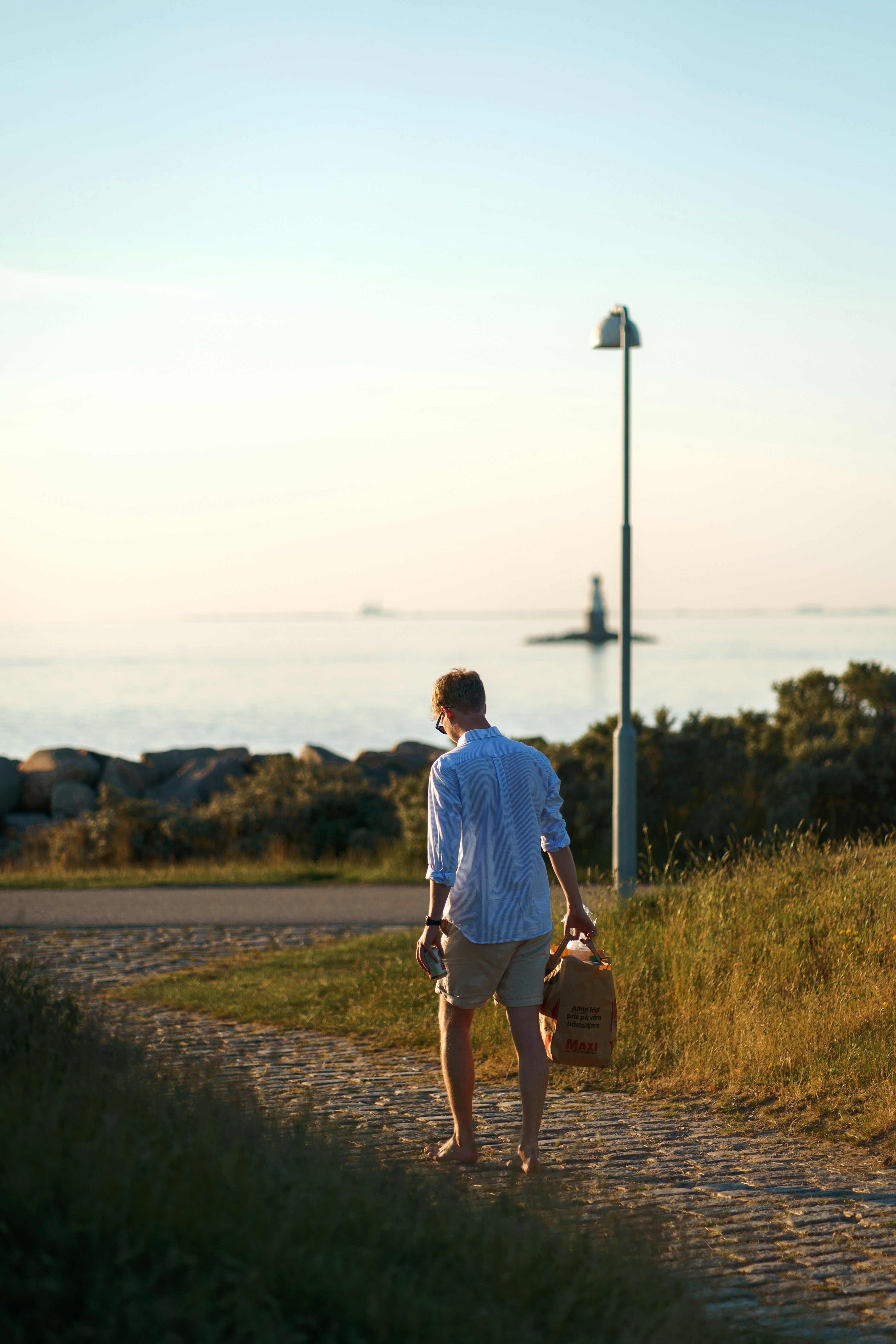 a man walking down a dirt road with a suitcase