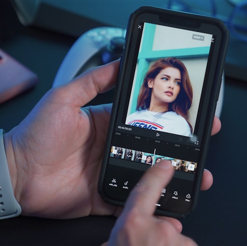 a person holding a cell phone with a picture of a woman on the screen