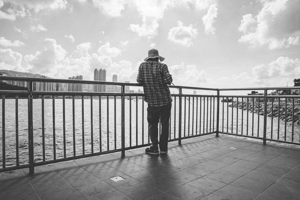 a person standing in front of a pier next to a body of water