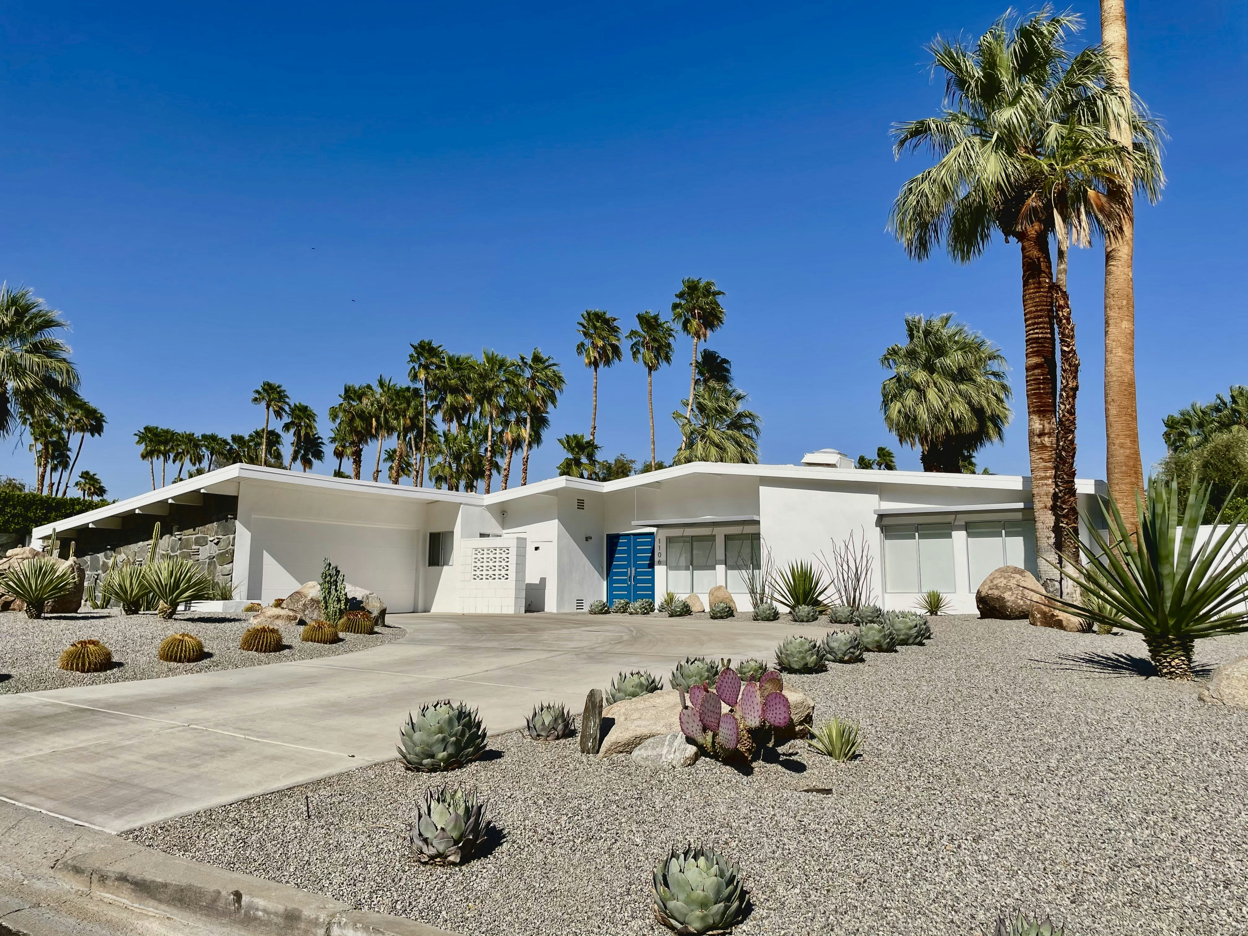 a white house with palm trees in front of it, Mid Century Modern in Palm Springs.