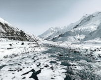 a river running through a snow covered mountain valley