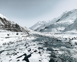a river running through a snow covered mountain valley