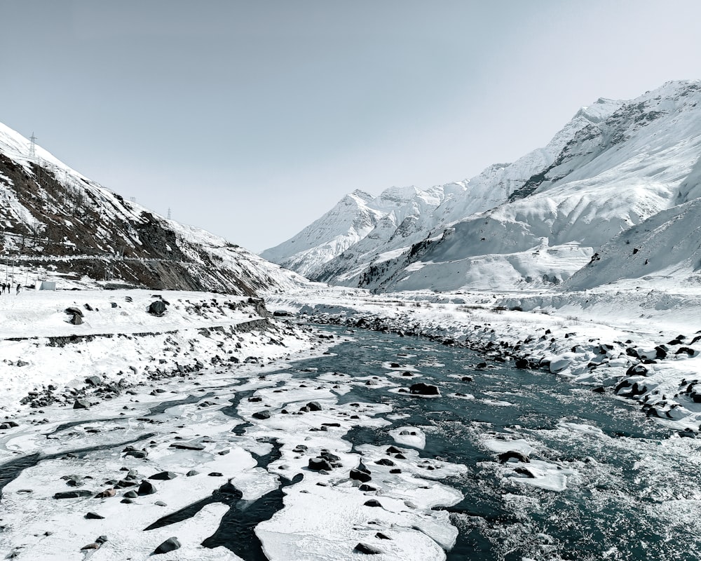 Ein Fluss, der durch ein schneebedecktes Bergtal fließt