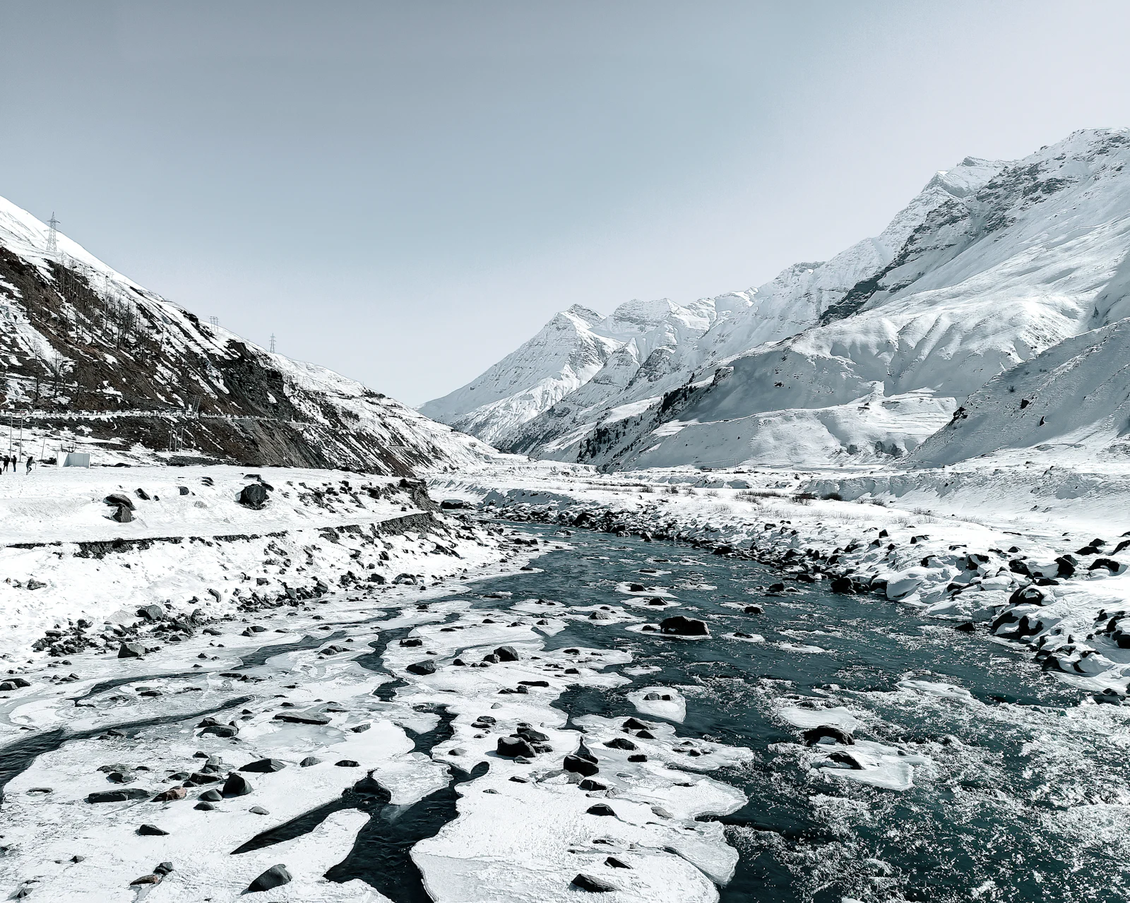 A river winding through a snow-covered Himalayan mountain valley in Sissu, Himachal Pradesh near Manali