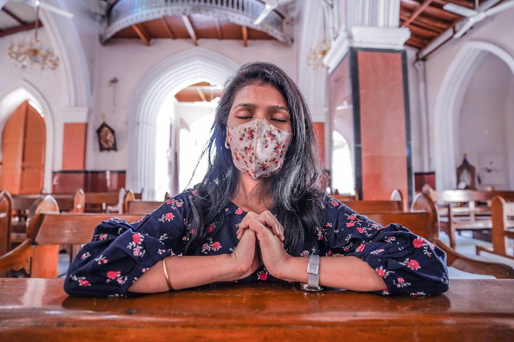 uma mulher usando uma máscara facial em uma igreja