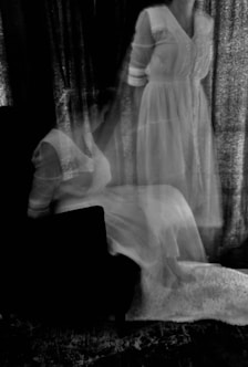 a black and white photo of a woman in a white dress