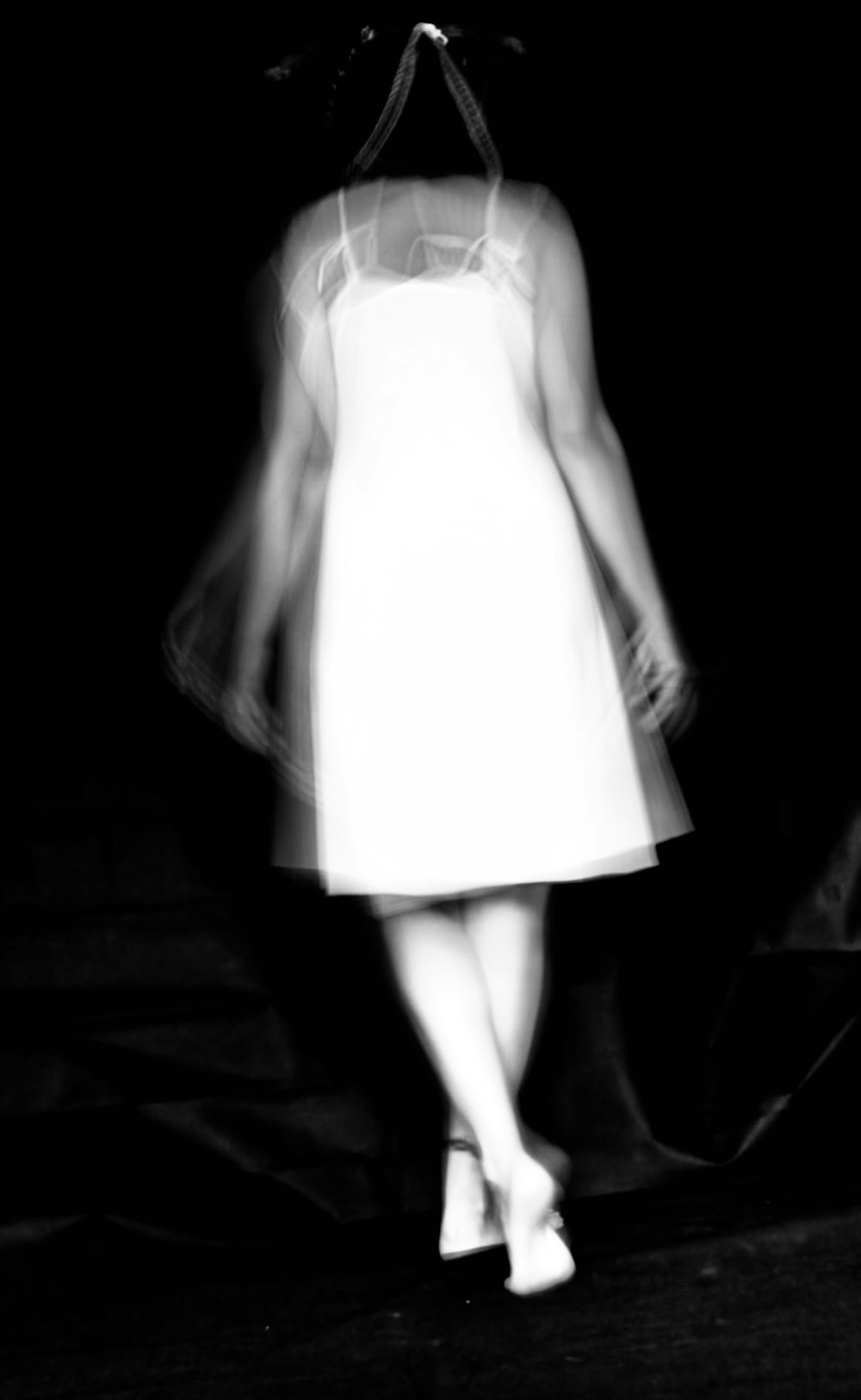 a black and white photo of a woman in a dress
