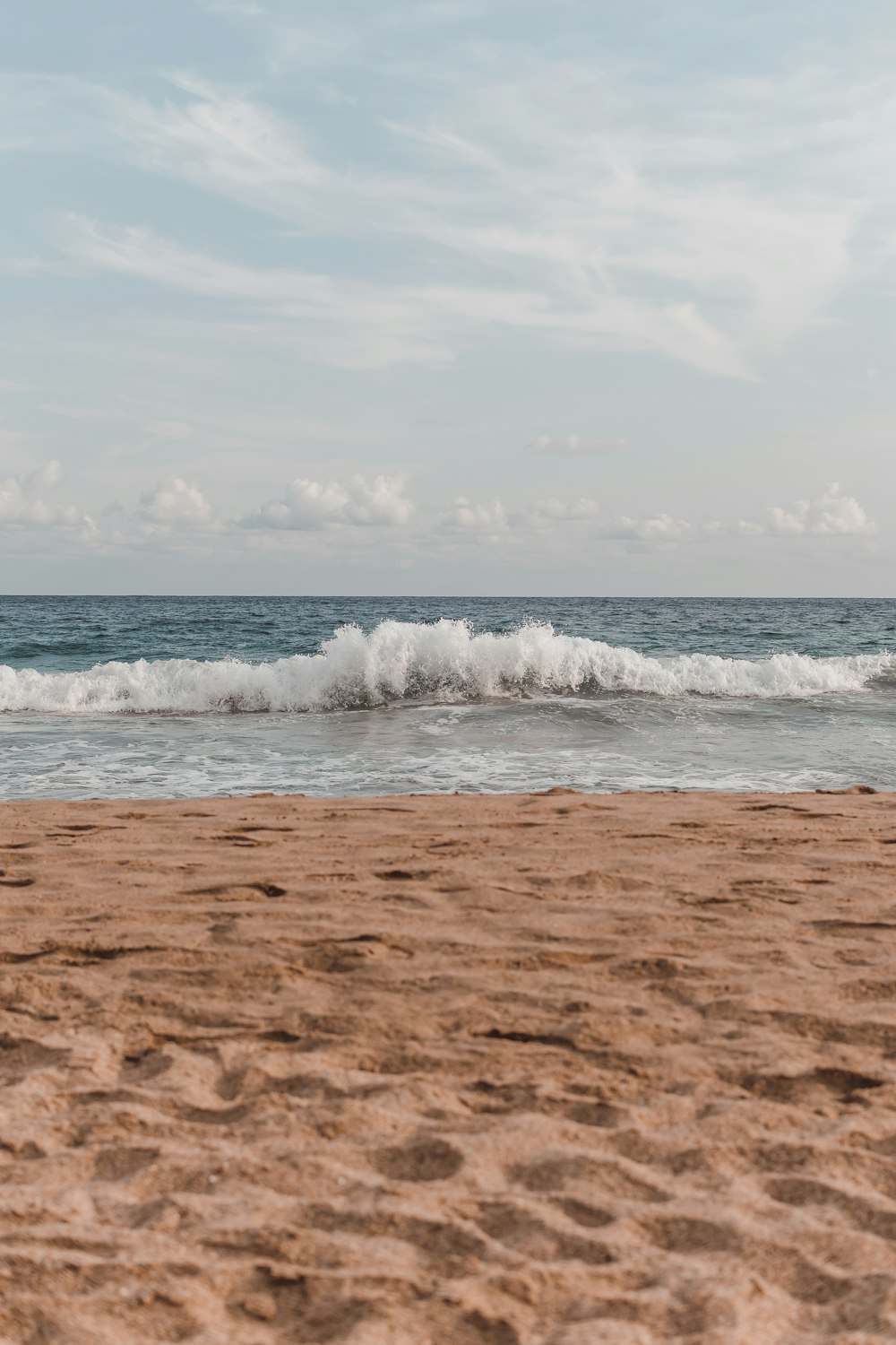 a person walking on a beach with a surfboard