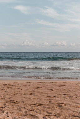 a person walking on the beach with a surfboard