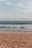 a person walking on the beach with a surfboard