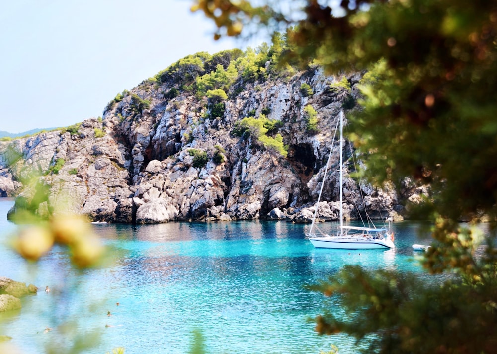 a sailboat floating in the blue water of a bay