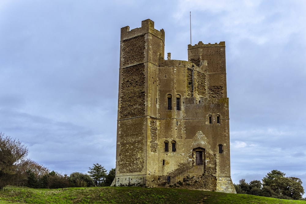 a tall tower sitting on top of a lush green hillside