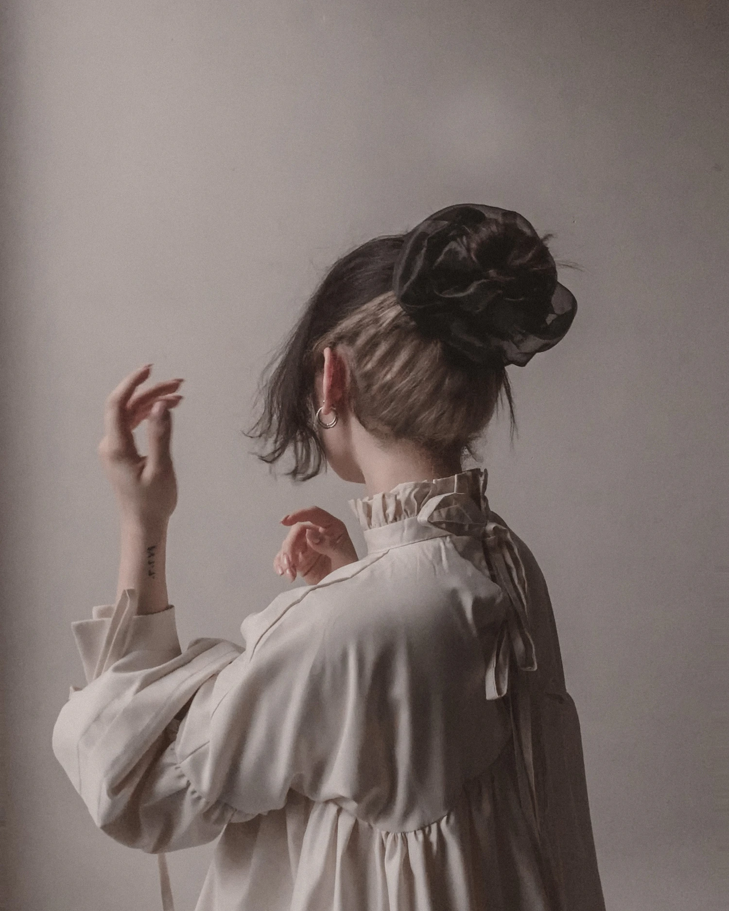 A cream shirt with a gathered collar seen from behind
