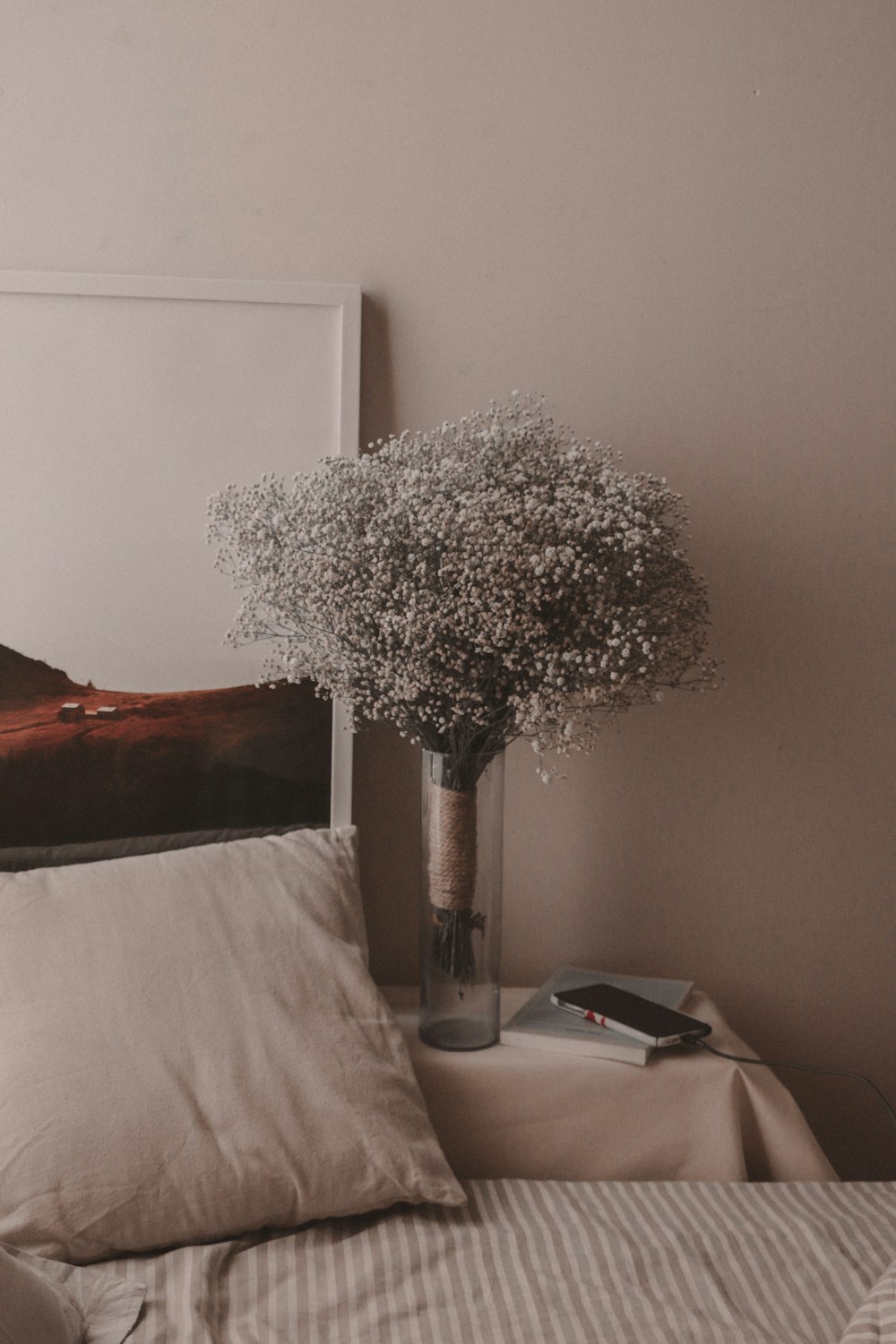 a vase of baby's breath sitting on a bed