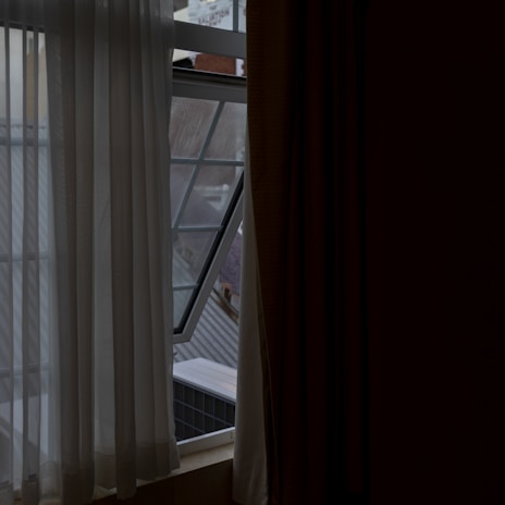 Rahem llc blackout curtains partially open revealing bright outdoor sunlight.