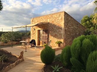 a stone house in Mallorca with a patio and umbrella