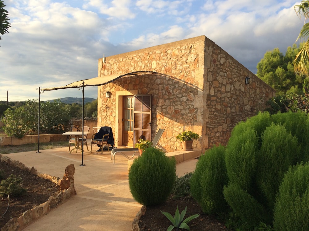 a stone building with a patio and umbrella