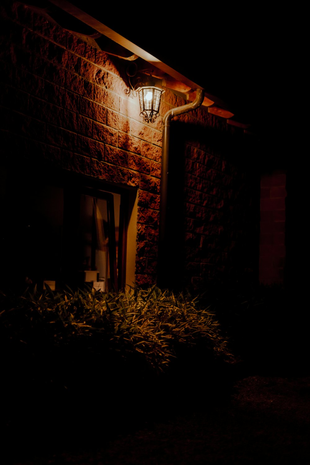 a light shines on the side of a brick building