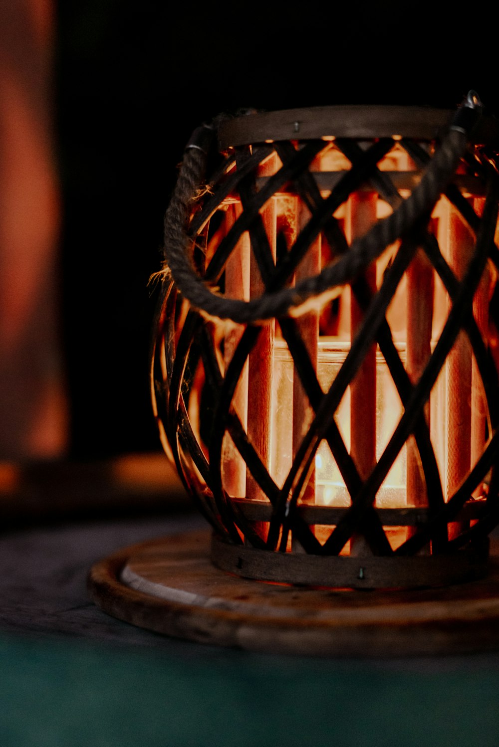 a lit candle sitting on top of a wooden stand