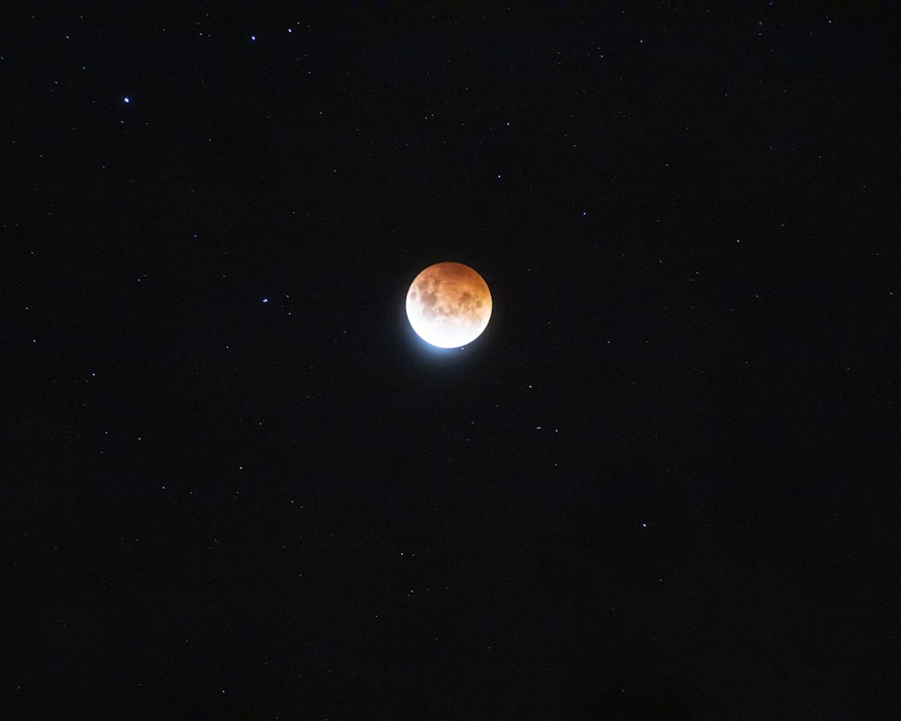a red moon is seen in the night sky
