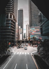 a city street with tall buildings in the background