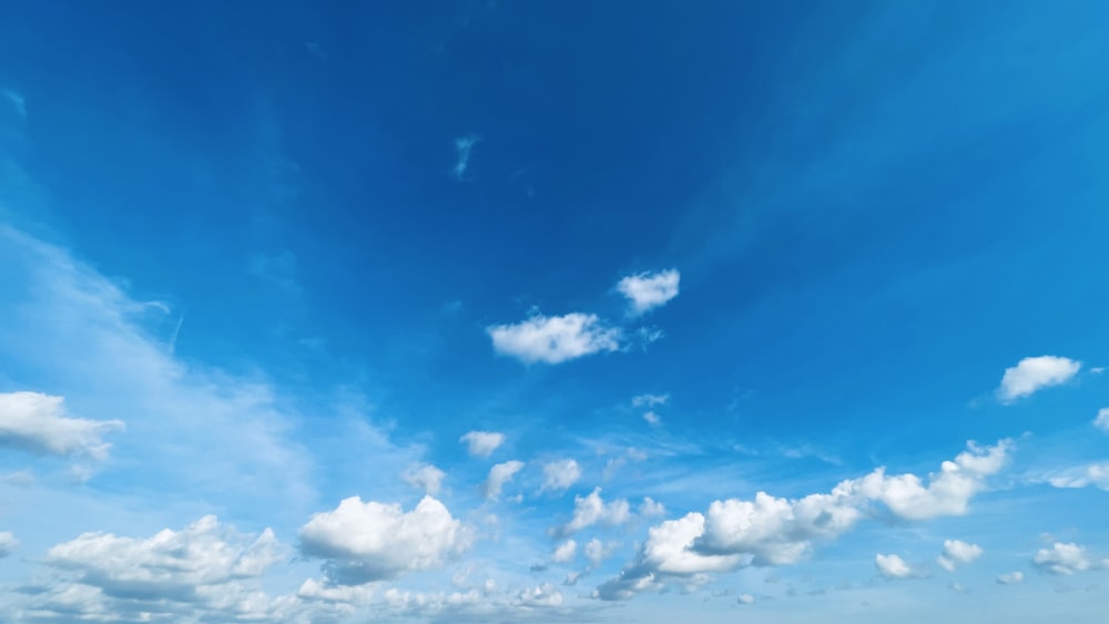 a blue sky with white clouds over a beach