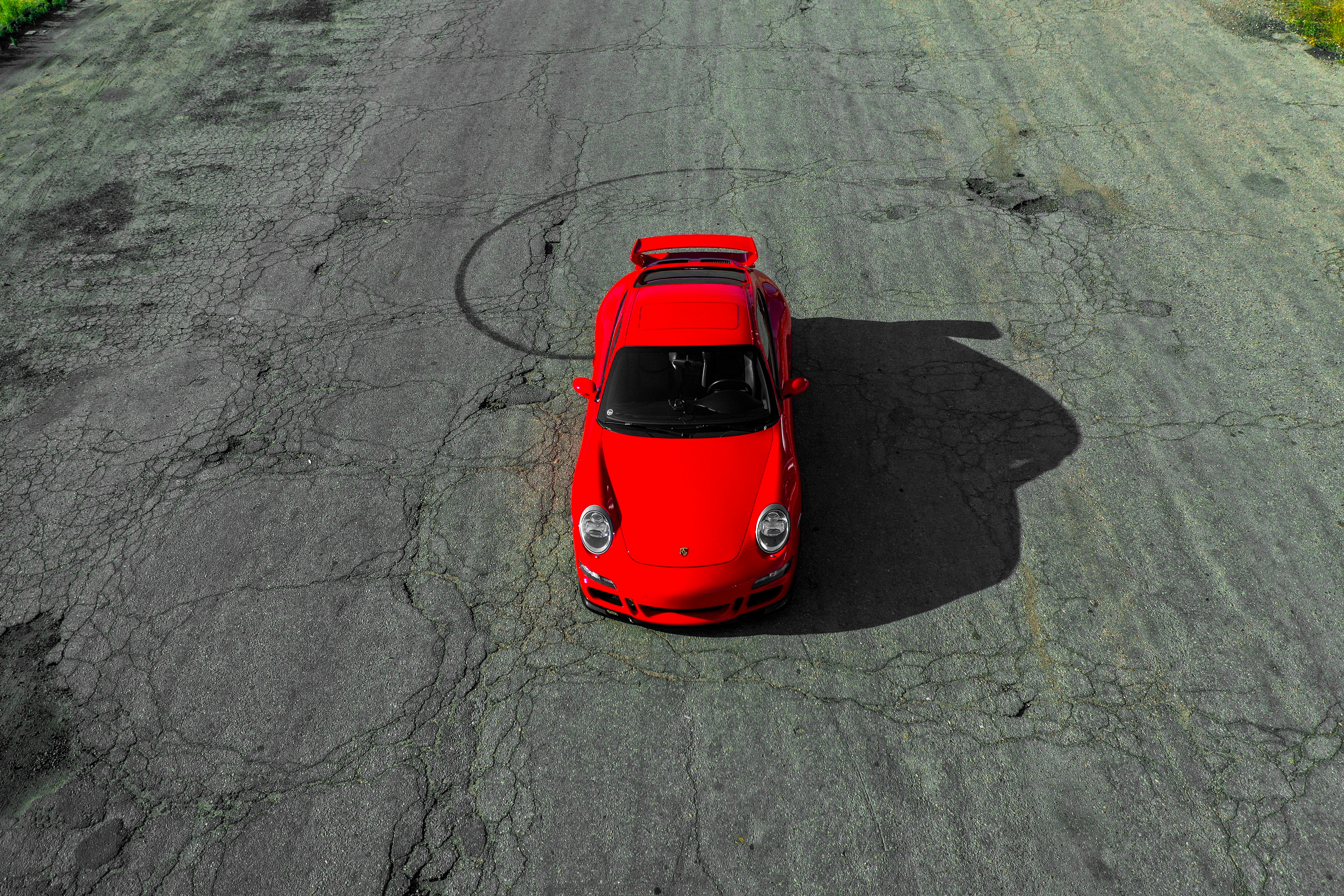 a red car is parked on the side of the road