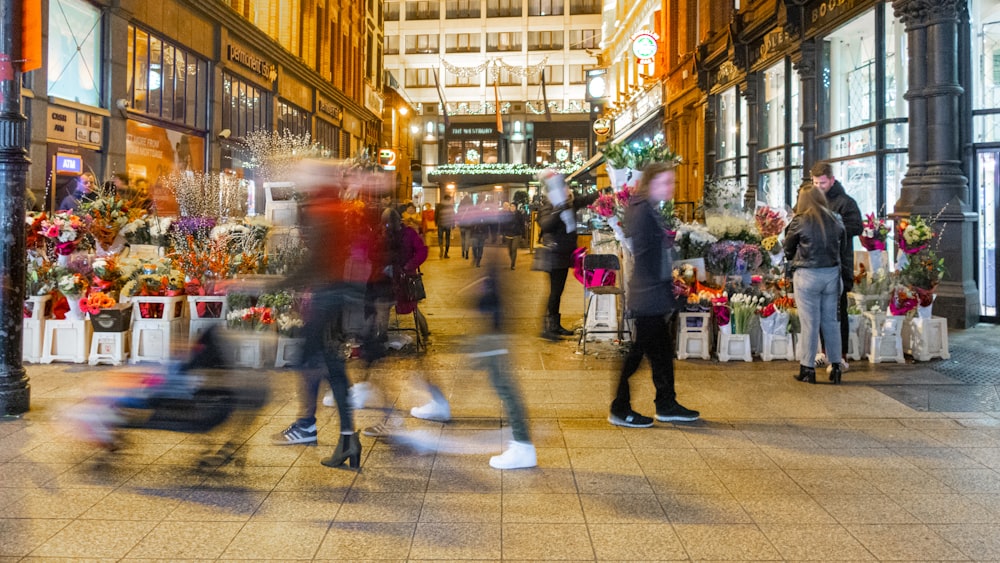 a crowd of people walking down a street next to tall buildings