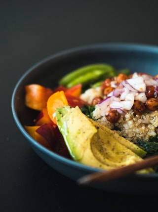 a blue bowl filled with rice and veggies