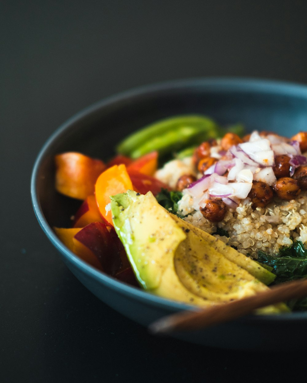 a blue bowl filled with rice and veggies