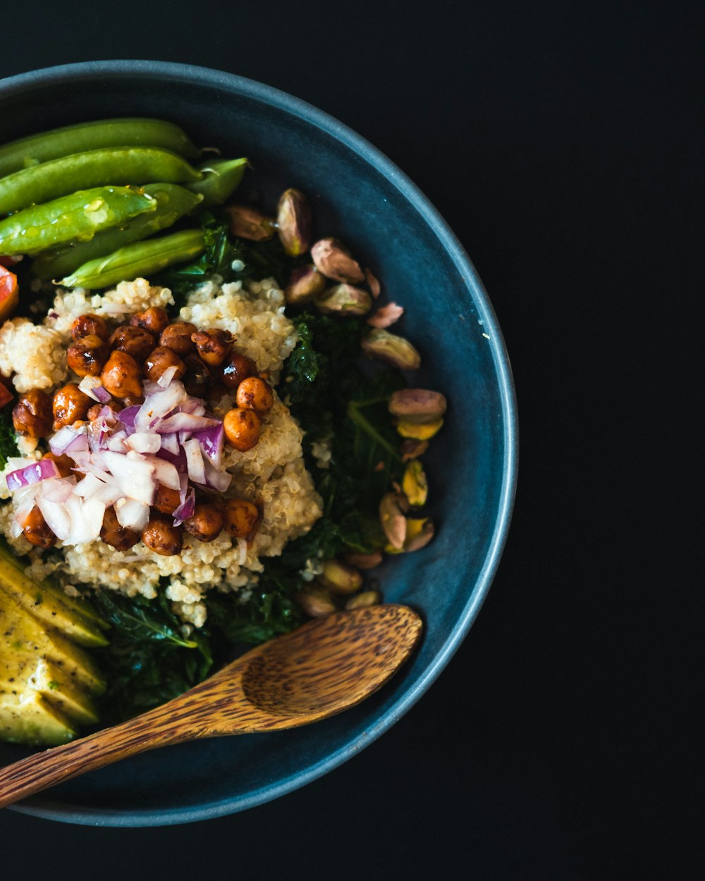 a blue bowl filled with vegetables and rice