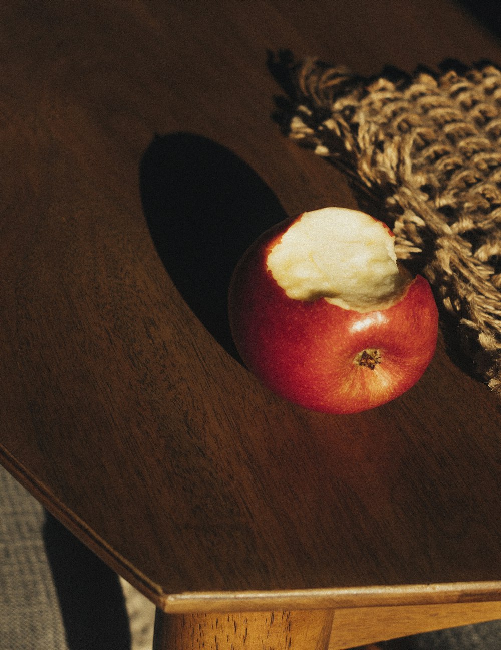 uma maçã vermelha sentada em cima de uma mesa de madeira