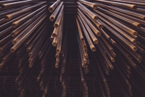 Bundles of polished copper rods arranged in a warehouse.
