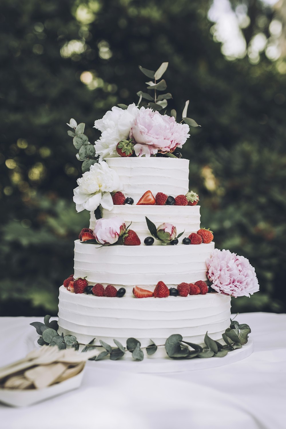 신선한 딸기와 꽃을 곁들인 하얀 웨딩 케이크