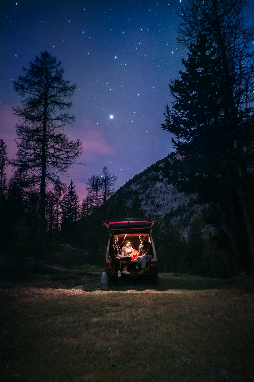 a group of people sitting in a golf cart under a night sky