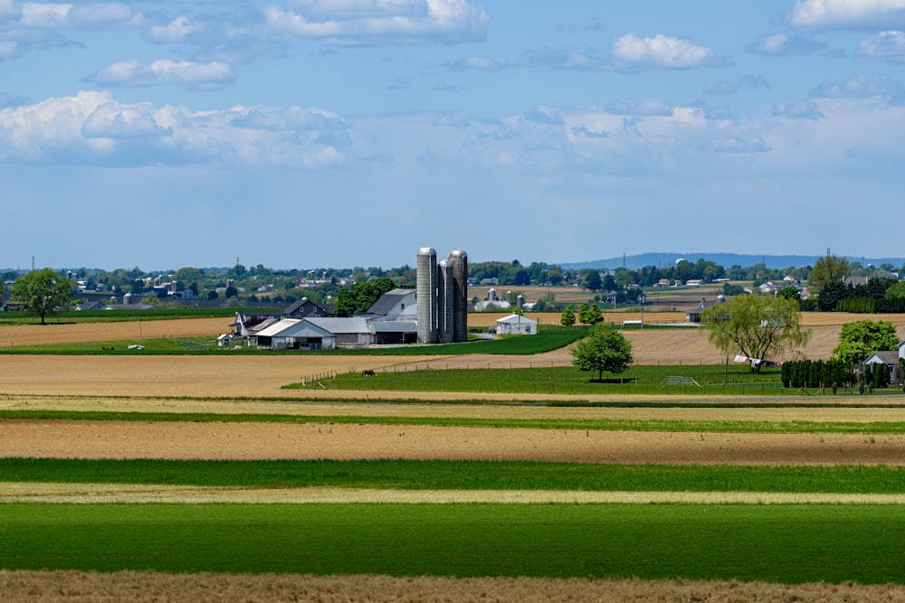 a farm with a grain silo in the distance